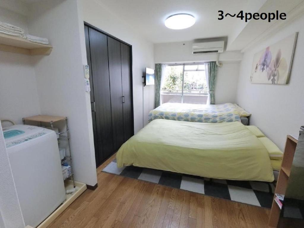 a small bedroom with a bed and a window at Sun Heights Ikebukuro in Tokyo