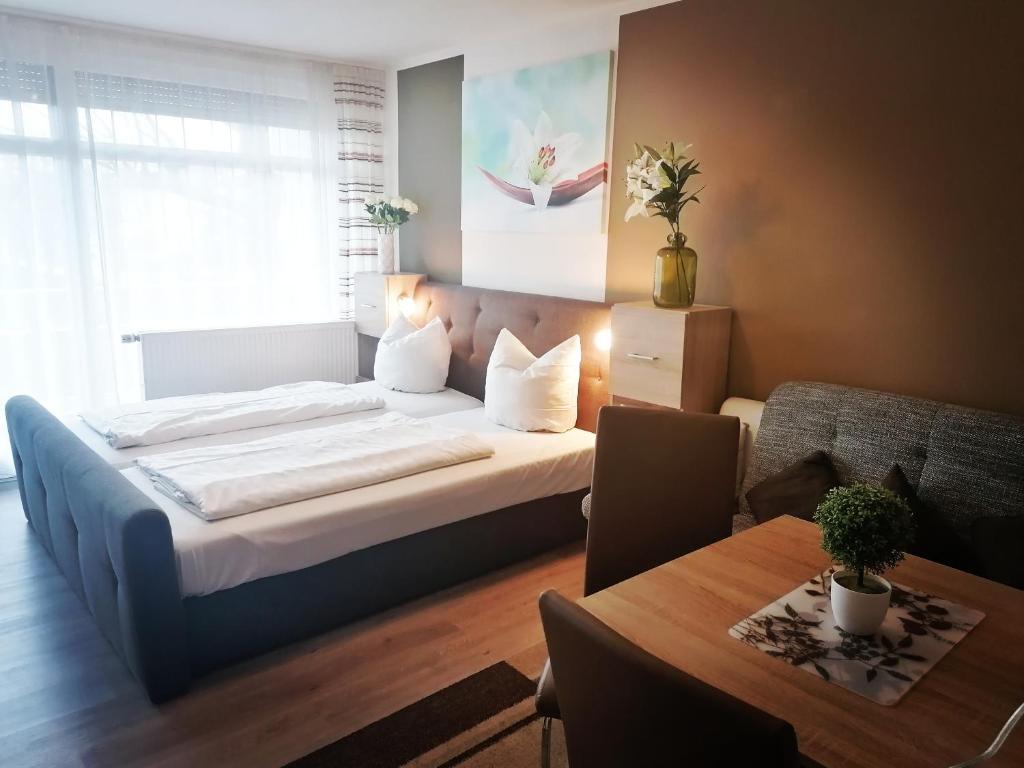 1 dormitorio con 1 cama grande y 1 mesa en Appartementhaus Nürnberg, en Bad Füssing