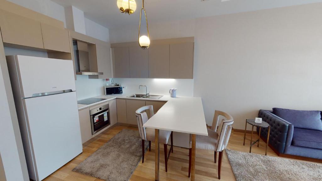 a kitchen and dining room with a white table and chairs at Maslak Aparts in Istanbul