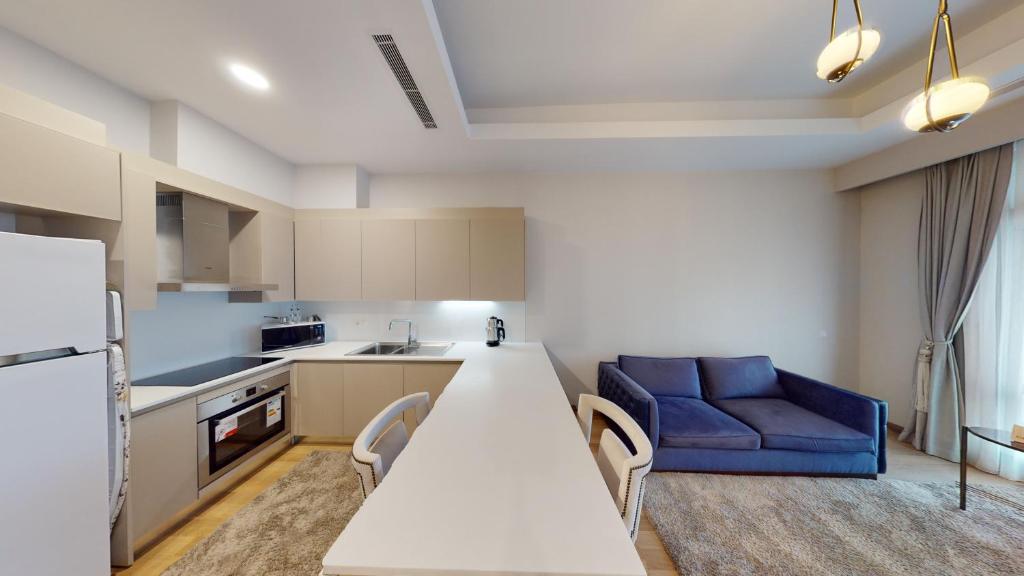 a kitchen with a white table and a blue couch at Maslak Aparts in Istanbul