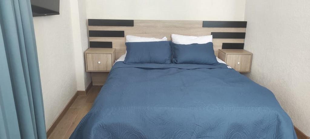 a bedroom with a blue bed with blue sheets and pillows at Nias's Apartment in Bakuriani in Bakuriani