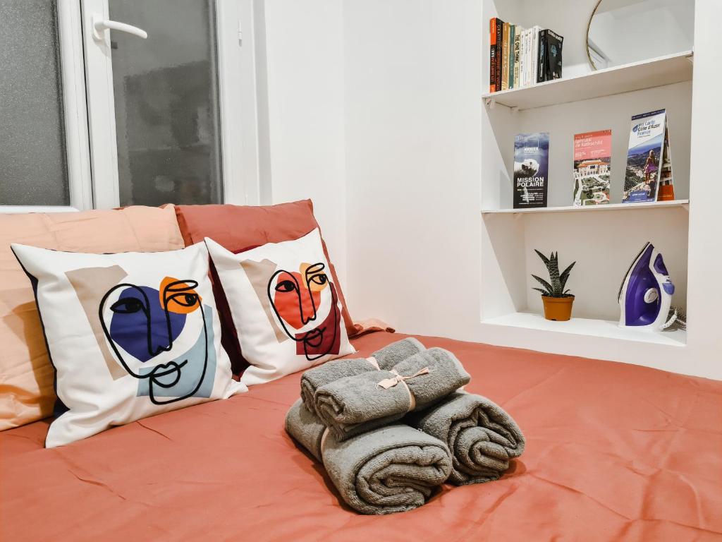 un lit avec un tas d'oreillers dessus dans l'établissement Cosy studio VIEUX NICE à 2 pas de la MER, à Nice