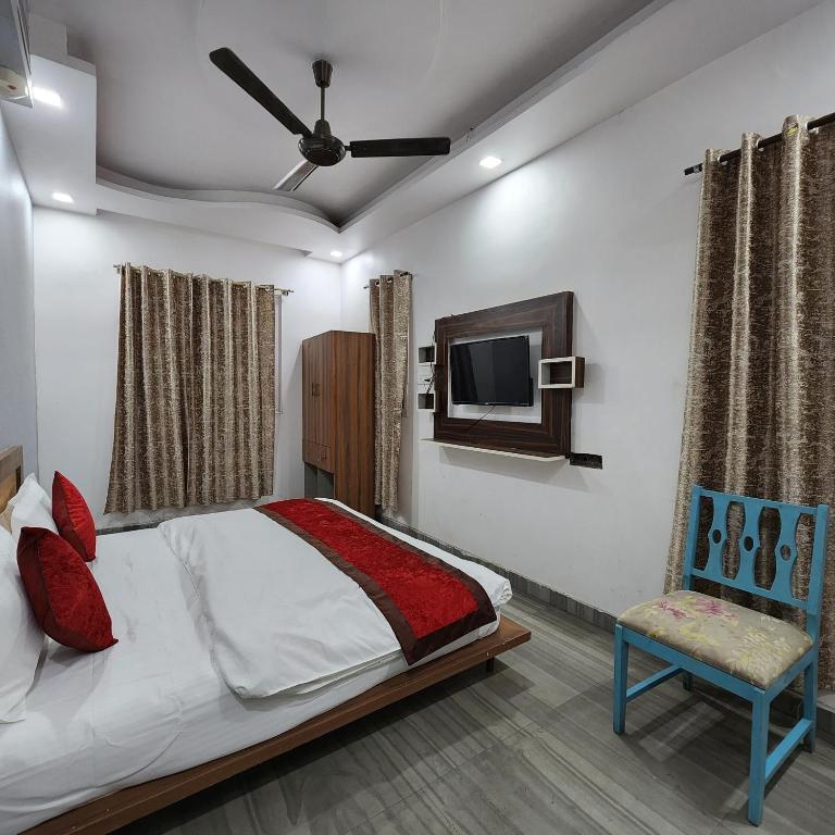 - une chambre avec un lit, une télévision et une chaise dans l'établissement HOTEL ROYAL AFGHAN, à New Delhi
