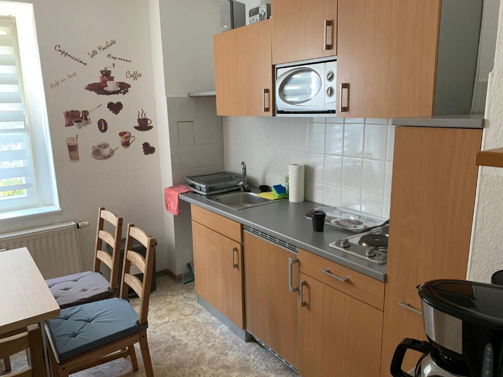 eine kleine Küche mit Spüle und Mikrowelle in der Unterkunft LEA Apartments Leipzig West in Leipzig