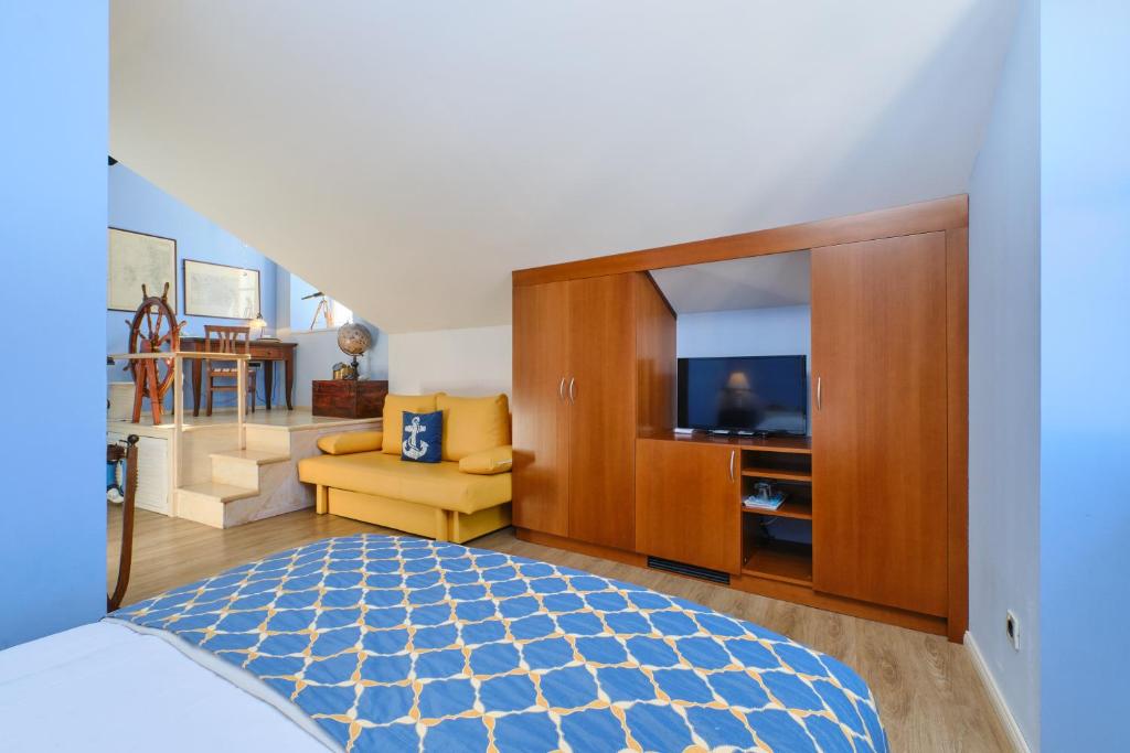 a bedroom with a bed and a television in it at Mare Mare Suites in Mali Lošinj