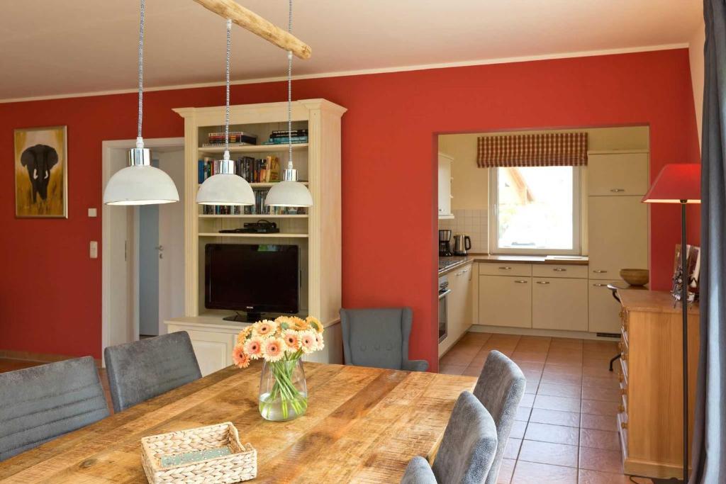 a dining room with a table with a vase of flowers at Ferienhaus Fernweh in Göhren-Lebbin