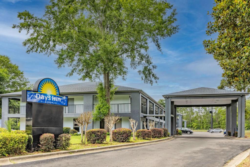 un hôtel avec un panneau devant un bâtiment dans l'établissement Days Inn by Wyndham Pensacola I-10, à Pensacola