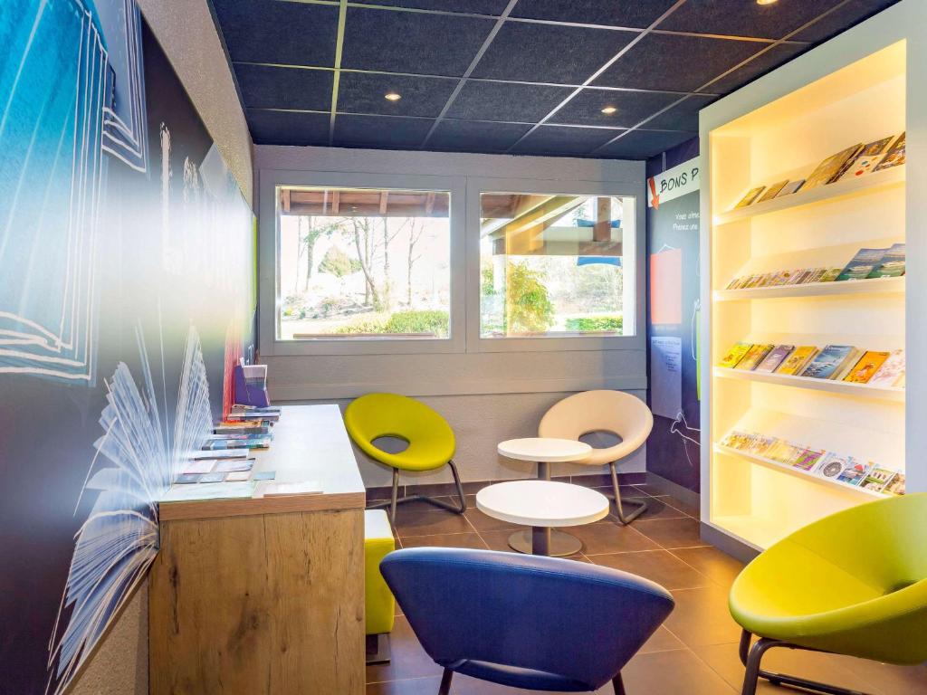 a store with colorful chairs and tables in a room at ibis budget Quimper in Quimper