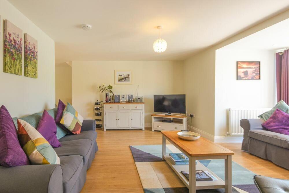 a living room with two couches and a table at Schooner Court No2 in Alnmouth