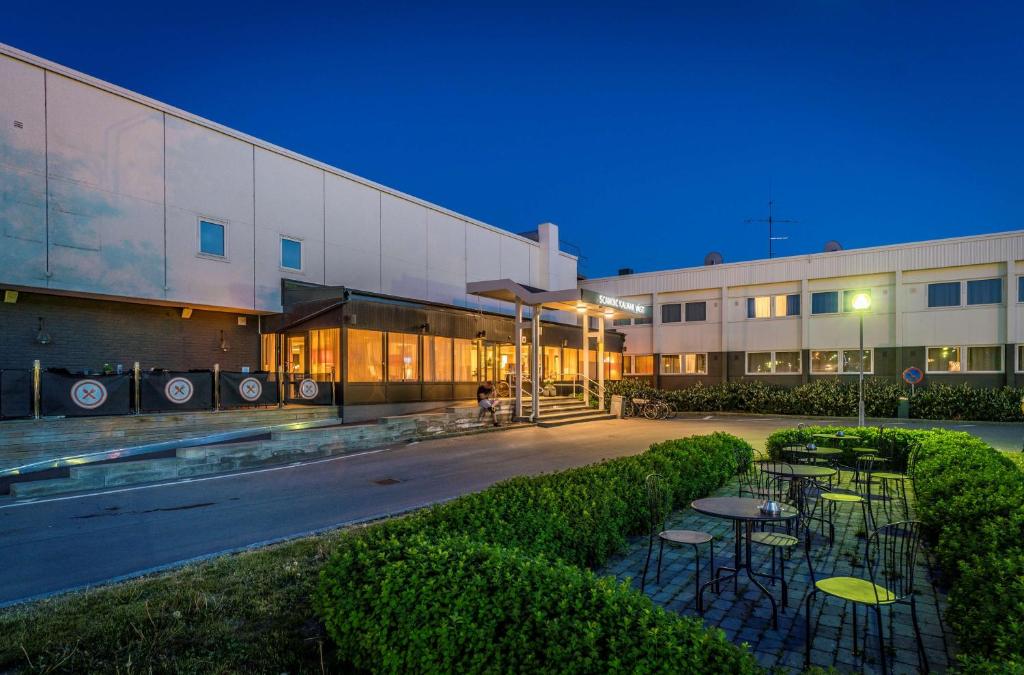 a building with tables and chairs in front of it at Scandic Kalmar in Kalmar