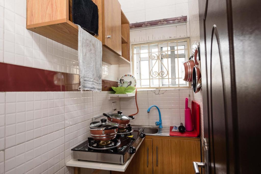 una cocina con fogones con ollas y sartenes. en Ebrina Apartments, en Port Harcourt