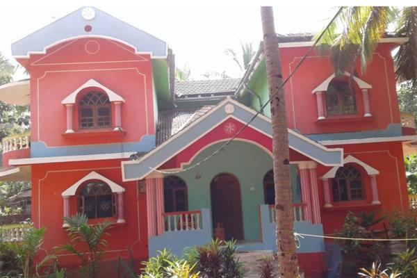 a large red and blue house with at Mayelle Agonda in Agonda