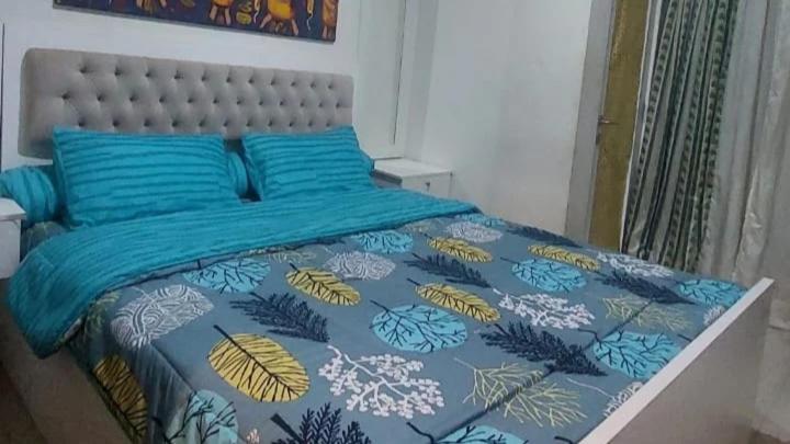 ein Schlafzimmer mit einem Bett mit einer blauen und gelben Tagesdecke in der Unterkunft Maxxy room grand Kamala lagoon in Pulosirih