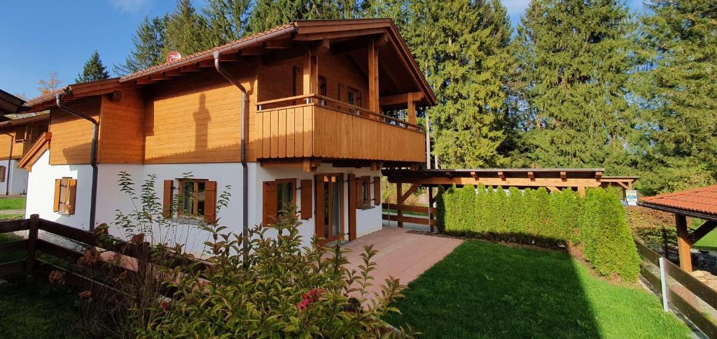 Casa de madera con balcón en un patio en Ferienhaus Happyplace, en Illach