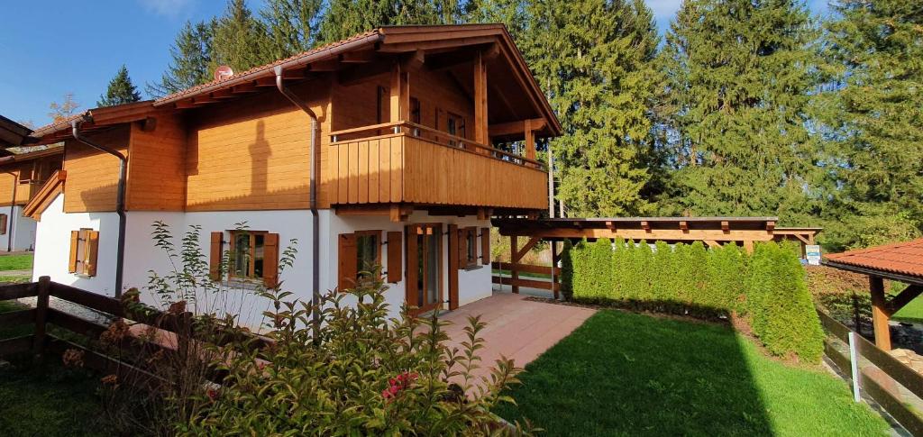 a wooden house with a balcony on a yard at Ferienhaus Happyplace in Illach