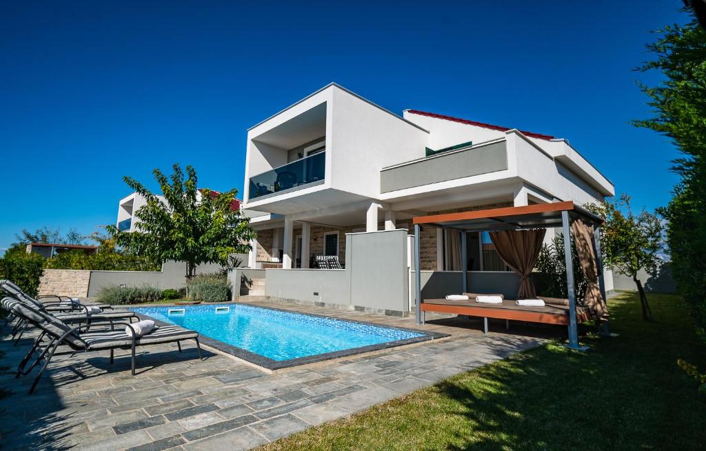 une villa avec une piscine et une maison dans l'établissement Villa Flavia and Alba - Private Heated Pool, à Novalja