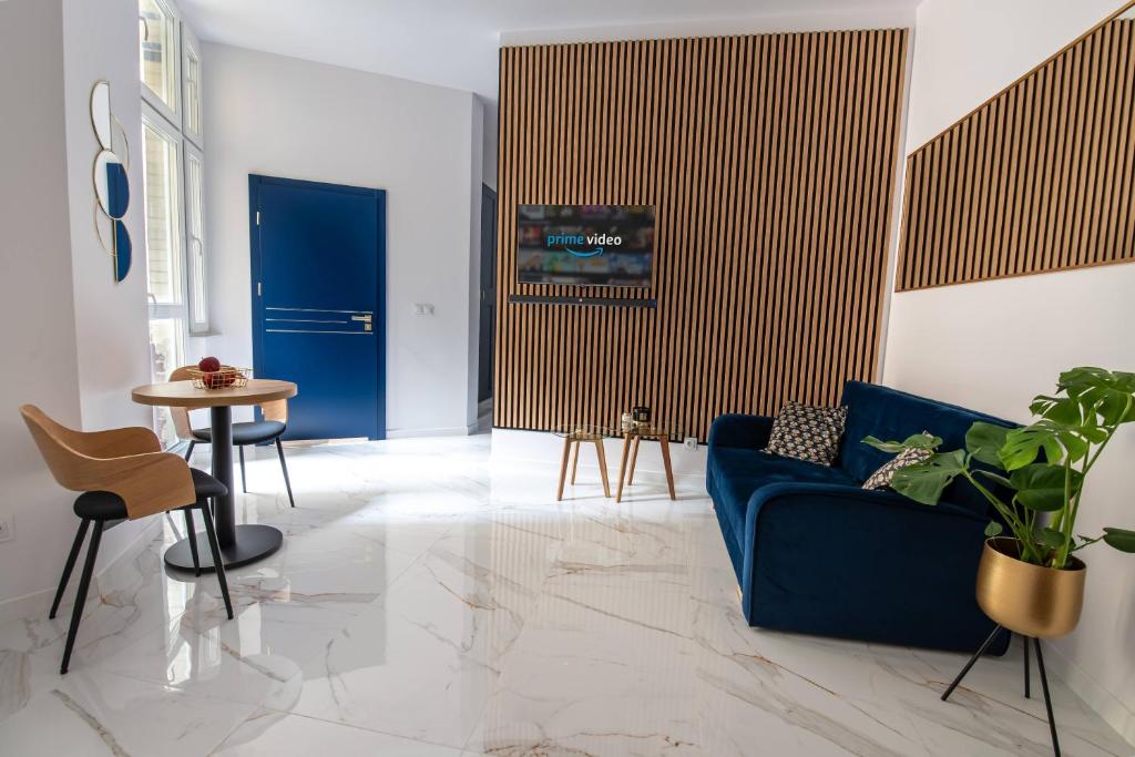 a living room with a blue couch and a table at Apartamenty Yeti & Wilka w Centrum Chorzowa - Yeti in Chorzów