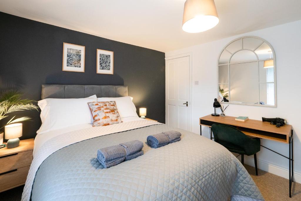 a bedroom with a bed with a desk and a desk at Stunning 2-bedroom home in city centre with Wi-Fi! in Royal Tunbridge Wells