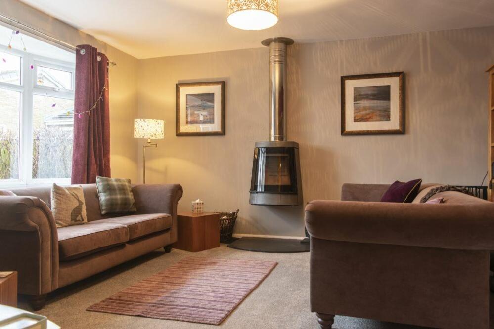 a living room with a couch and a wood stove at Our Story Cottage in Long Houghton