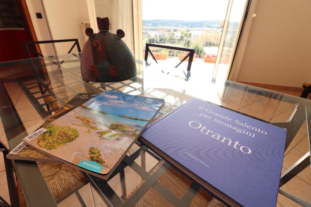 a glass table with two books and a backpack on it at Elegant Holiday Home for 67 Guests in the Heart of Otranto in Otranto