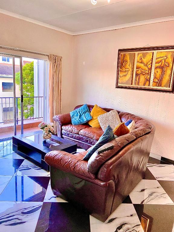 a living room with a leather couch and a table at The Beacon Fairy in East London
