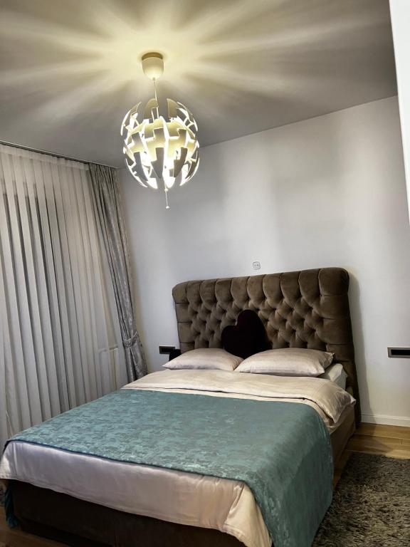 a bedroom with a large bed and a chandelier at Emma Park Lake in Tuzla