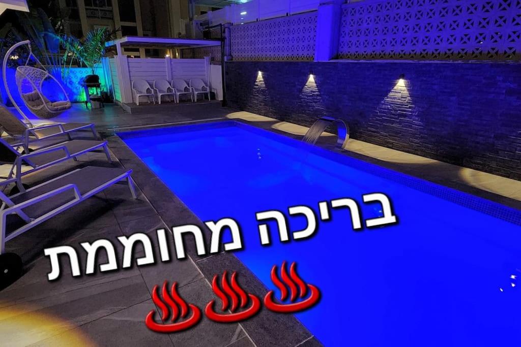 una piscina con una señal de luz azul en ella en סאן בוטיק אילת, en Eilat