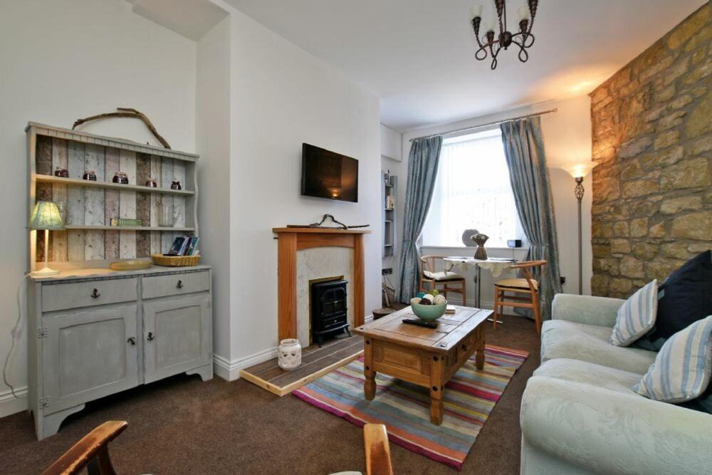 a living room with a couch and a fireplace at Sea Air in Amble