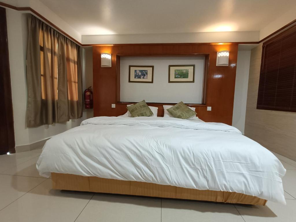 1 dormitorio con 1 cama grande con sábanas blancas en Pd full seaview deluxe en Port Dickson