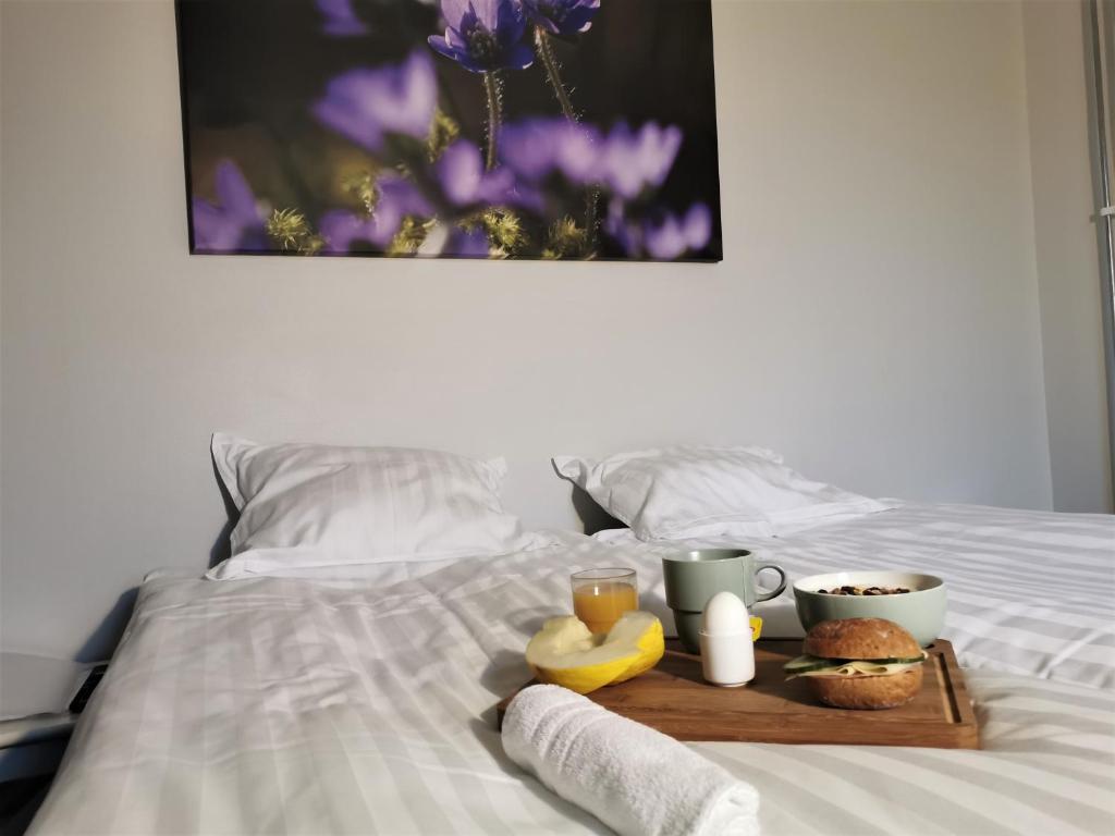 a tray with food and two cups of coffee on a bed at Broholm Bed&Breakfast in Lidköping