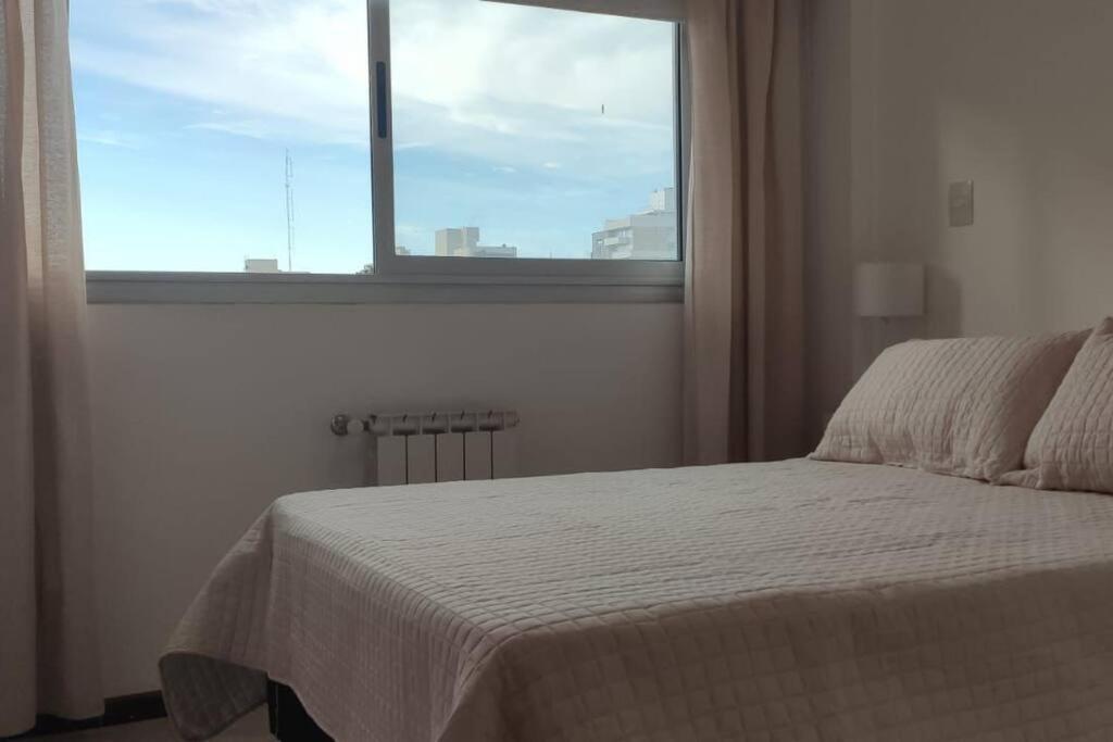 - une chambre avec un lit en face d'une fenêtre dans l'établissement Temporario La Plata 1 Frente a plaza Islas Malvinas! con Cochera Opcional, à La Plata