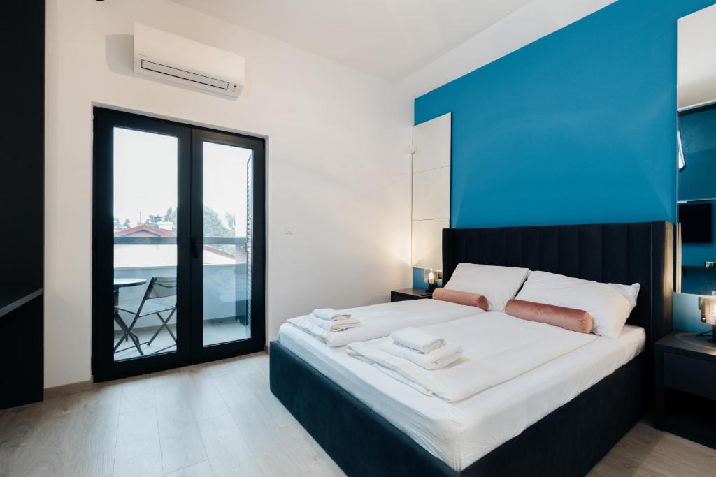 a bedroom with a large bed with a blue wall at Boutique Suites Joyce Medulin with free parking in Medulin