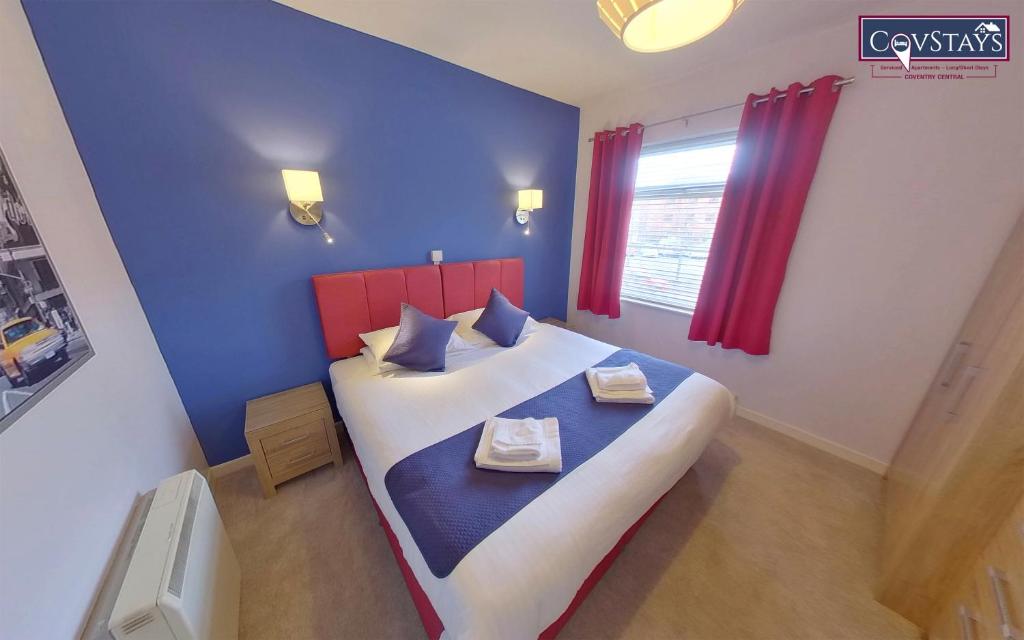 a bedroom with a large bed with blue and red walls at Sunnyside View - 1-bed Apartment in Coventry City Centre in Coventry