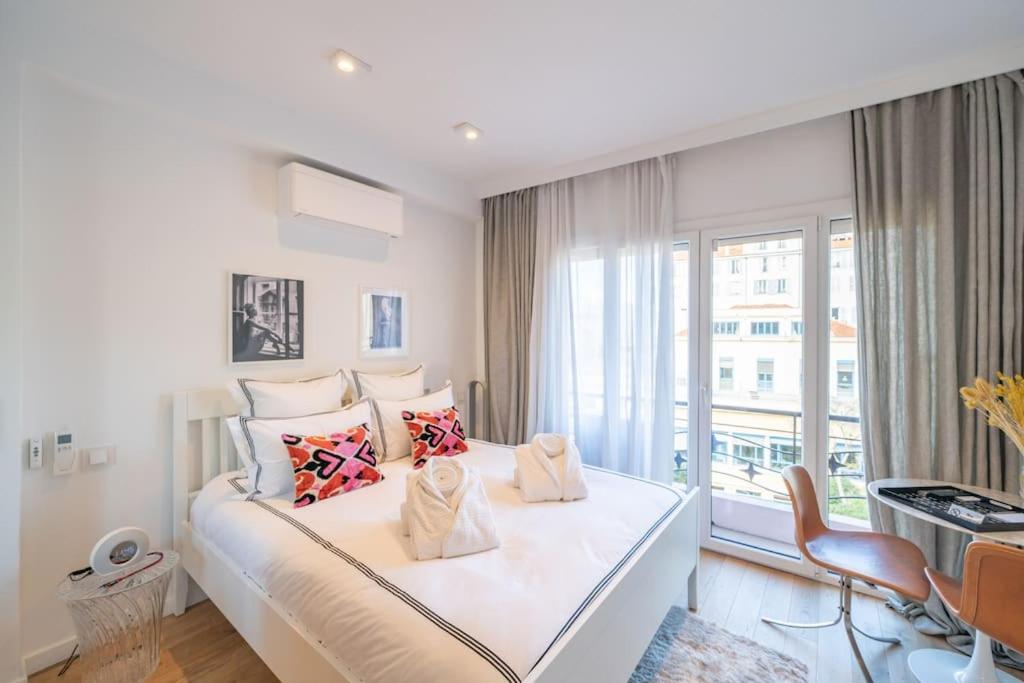una camera bianca con un grande letto e una finestra di Luxury Apartment - 150m to Palais des Festivals ( Cannes ) a Cannes