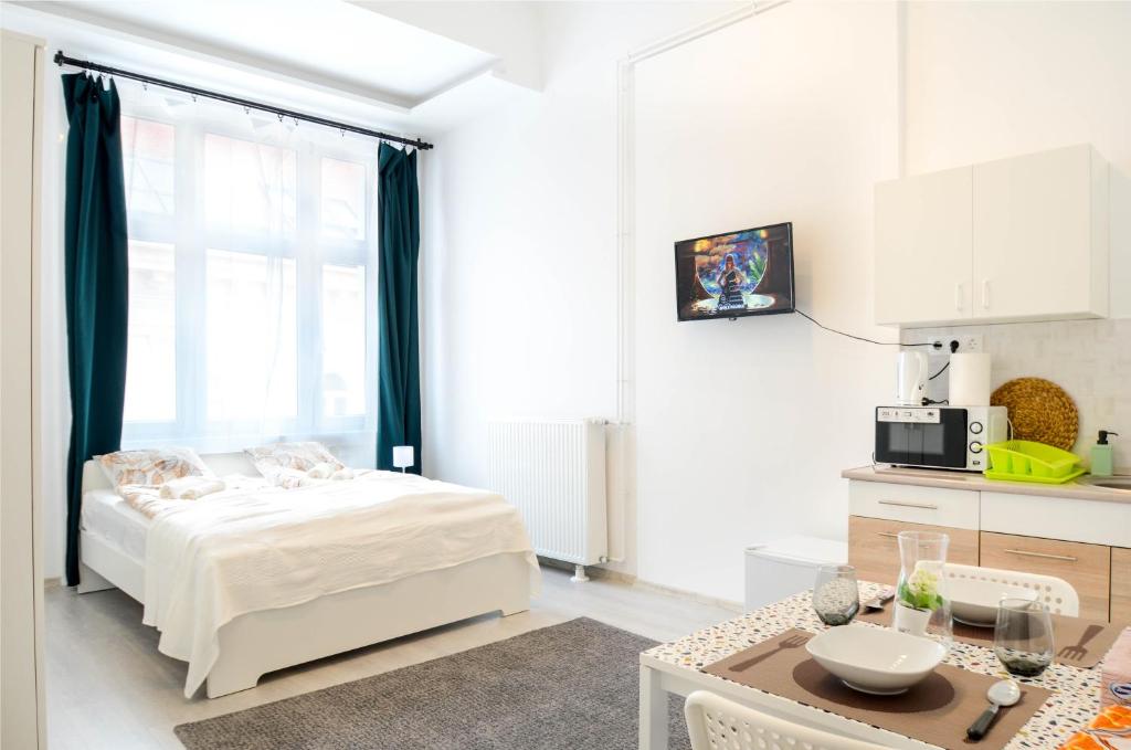 um quarto com uma cama, uma mesa e uma cozinha em Papnövelde Royal Inn @Inner City em Budapeste