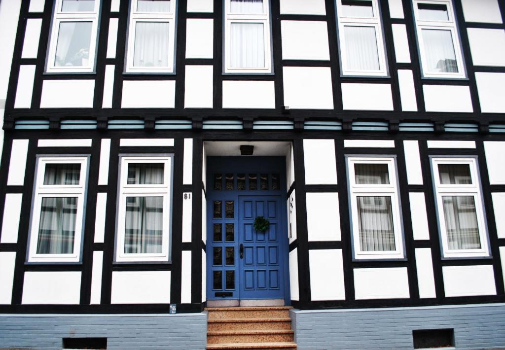 戈斯拉爾的住宿－Appartementhaus Klingebiel，一座黑白的建筑,设有蓝色的门