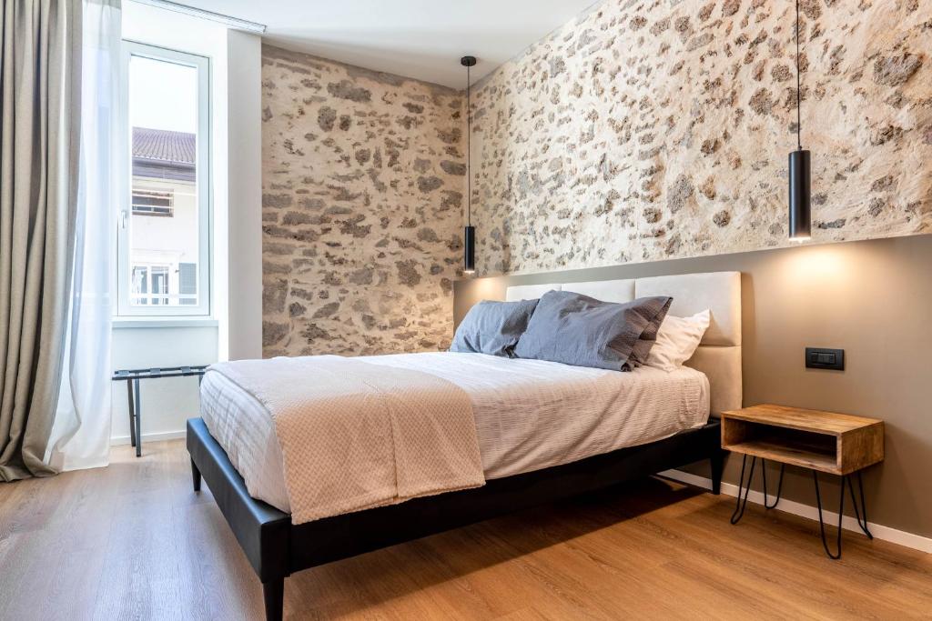 a bedroom with a bed with a stone wall at The Place - Only Self Check-in - No Reception in Trento