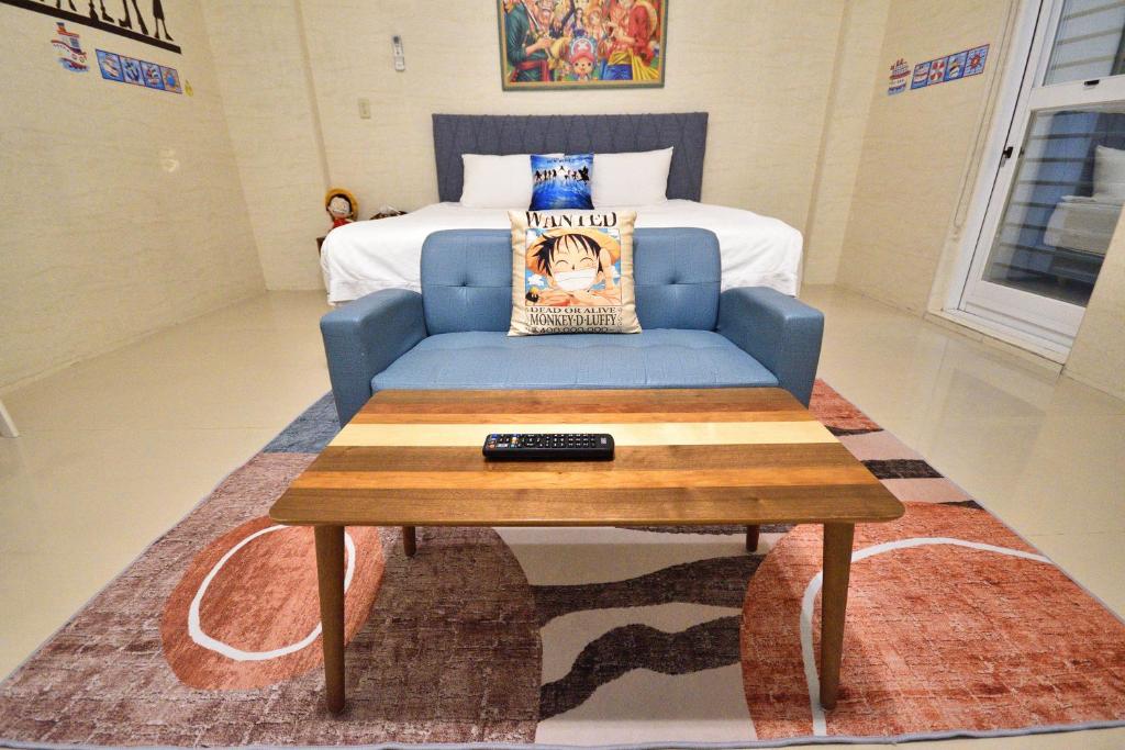 a living room with a blue couch and a bed at Piau Po 21 Inn in Taitung City