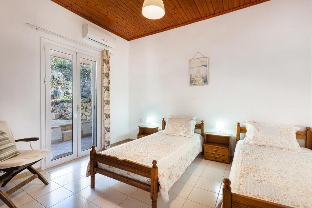 a bedroom with two beds and a window at Levanda Villas - Country villas with private pool in Exopoli