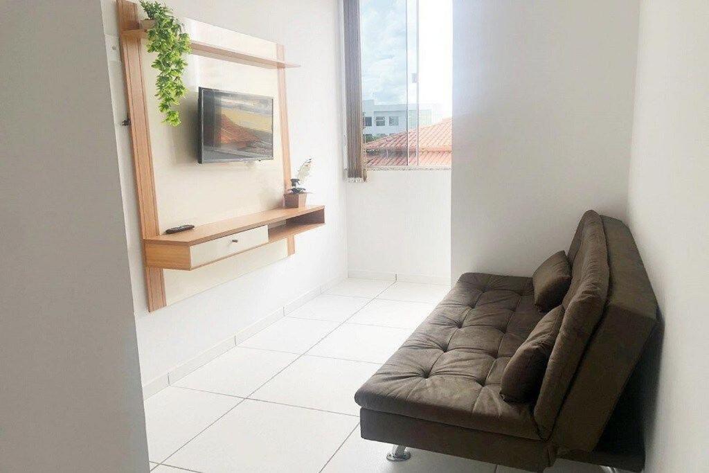 uma sala de estar com um sofá e uma televisão em 202-FLAT-Espaço,conforto.È disso que você precisa! em Anápolis