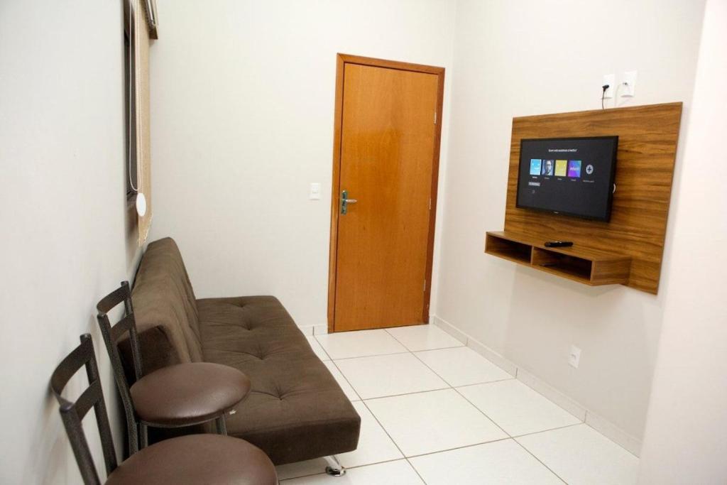 ein Wohnzimmer mit einem Sofa und einem TV in der Unterkunft 204-FLAT-Espaço,conforto.È disso que você precisa! in Anápolis