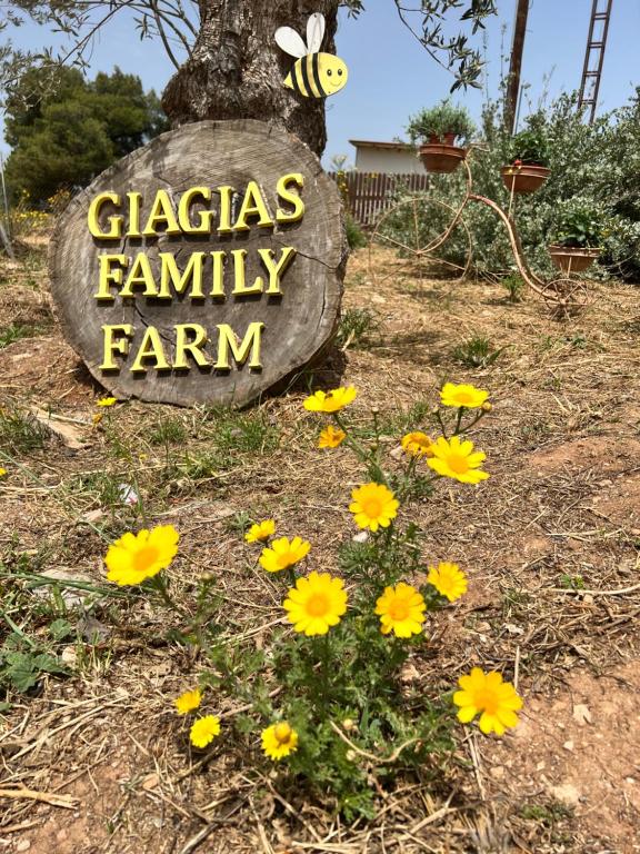 a sign that says glaziers family farm with yellow flowers at giagias family farm in Kranidi