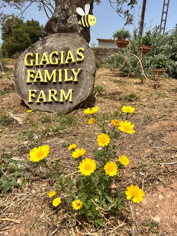 a sign that says glaziers family farm with yellow flowers at giagias family farm in Kranidi