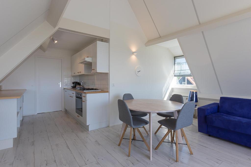 a kitchen and dining room with a table and chairs at Hello Zeeland - Appartement Brouwerijweg 43-2 in Domburg