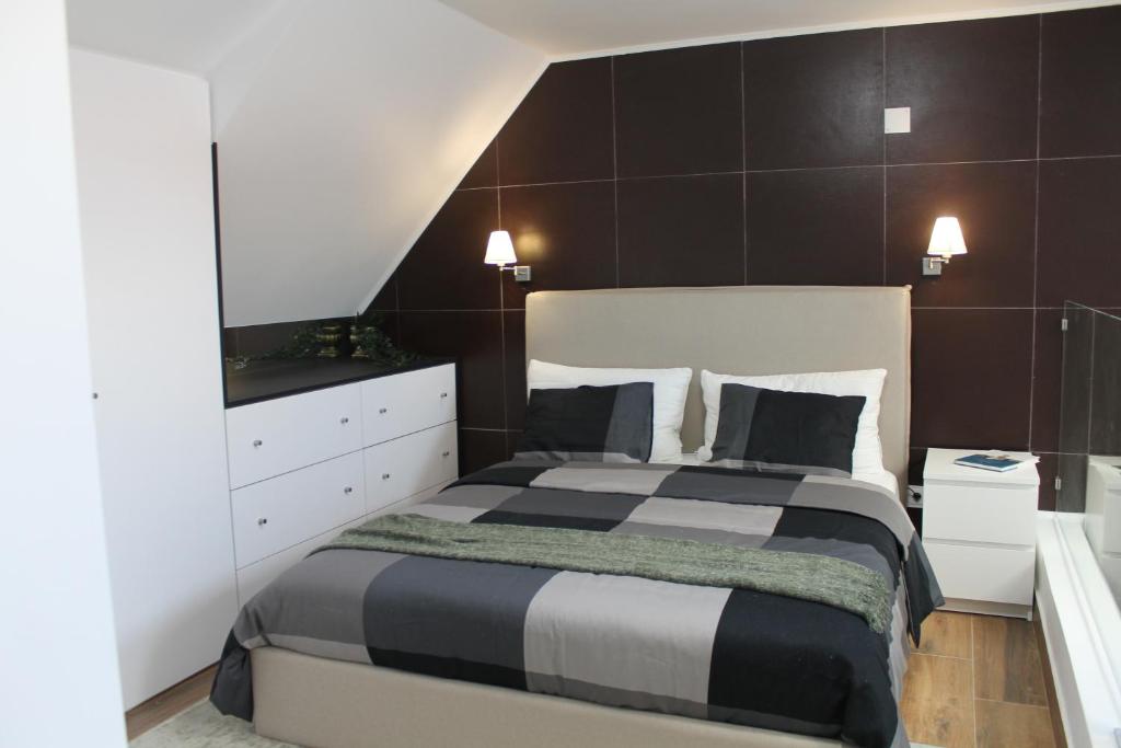 a bedroom with a black and white bed and a mirror at Terreirinho 1 e 2 in Sacavém