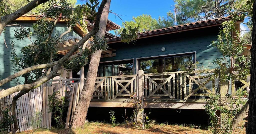 een blauw huis met een veranda met een hek bij Yamina Lodge in Cap-Ferret