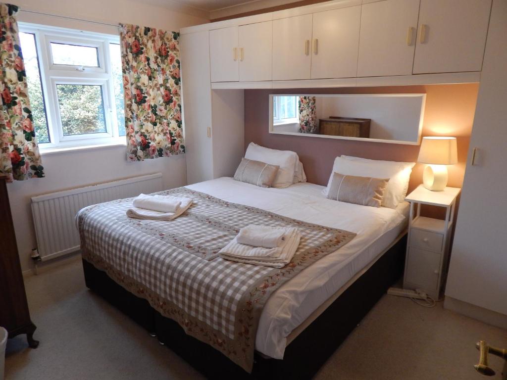 1 dormitorio con 1 cama con 2 toallas en Two bedroom corporate and family stay with parking in popular location, en Cambridge