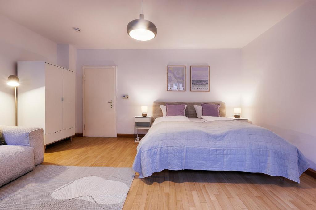 a bedroom with a large bed and a couch at Central, modern city apartments - by homekeepers in Würzburg