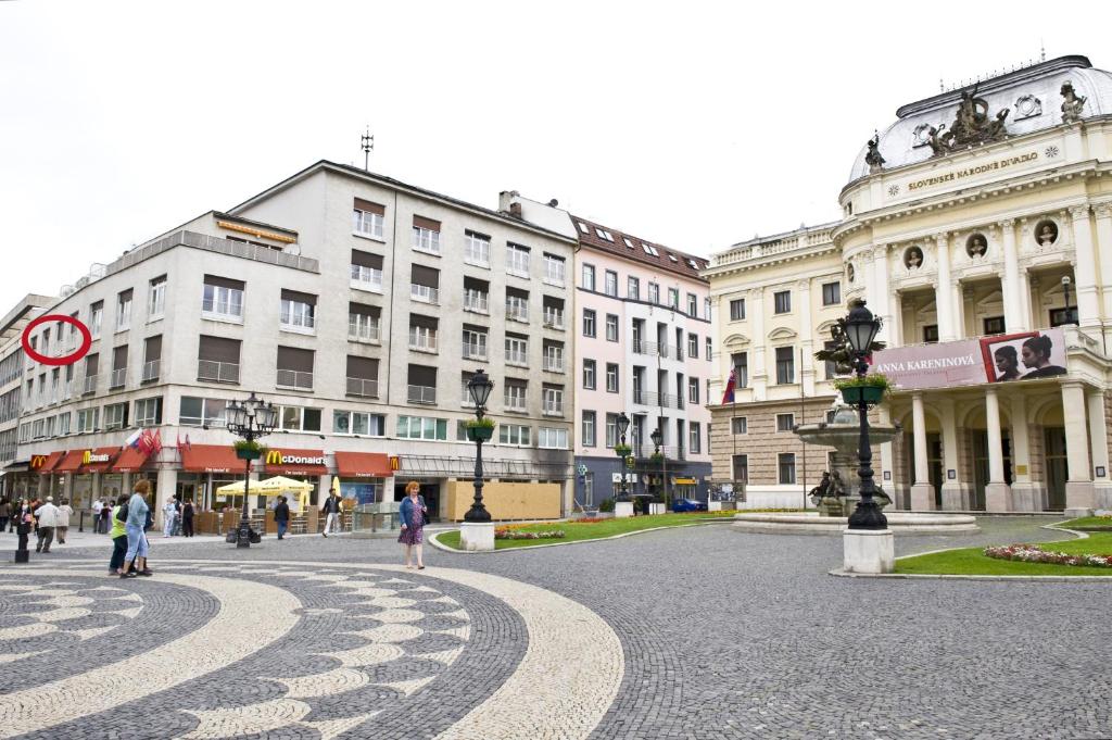 a city street with buildings and people walking around at Apartmán Old centre - Rybárska brána in Bratislava