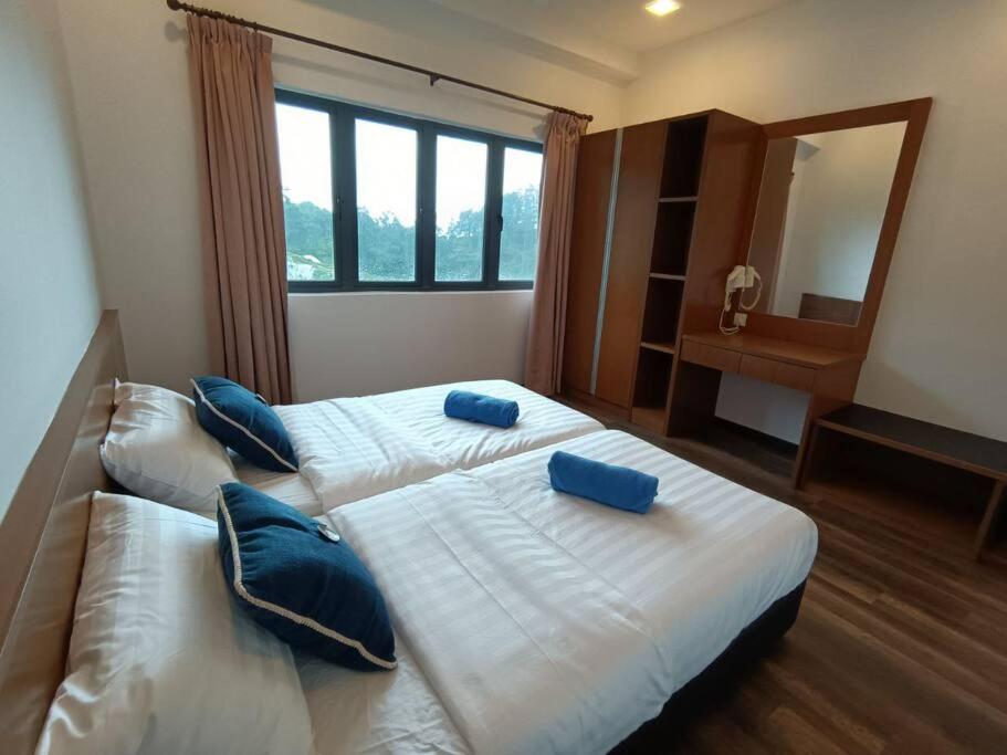 a bedroom with two beds with blue pillows on them at The Retreat Sweety 3BR H/Stay in Brinchang